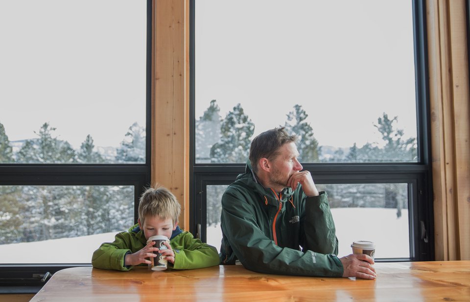 Father and son drinking hot chocolate at alpine cabin