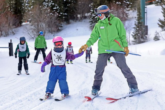 Kid and instructor holding hands